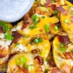 Best Irish pub nachos recipe crispy potato nachos with cheddar and ranch feature image close up with toppings and a side of ranch