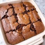 Feature image of dark chocolate brownies in a baking dish sliced and ready to serve.