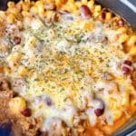 Cheesy pasta with ground beef feature image close up with melted cheese in dutch oven.