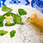 cilantro jalapeno dip chuys copycate recipe feature image close up in bowl with garnish being dipped