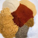 dry rub for oven baked ribs feature image spices grouped by color on plate