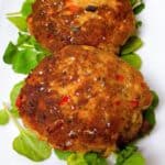 easy old fashioned salmon patties classic skillet recipe with canned salmon feature image close up of patties on bed of arugula