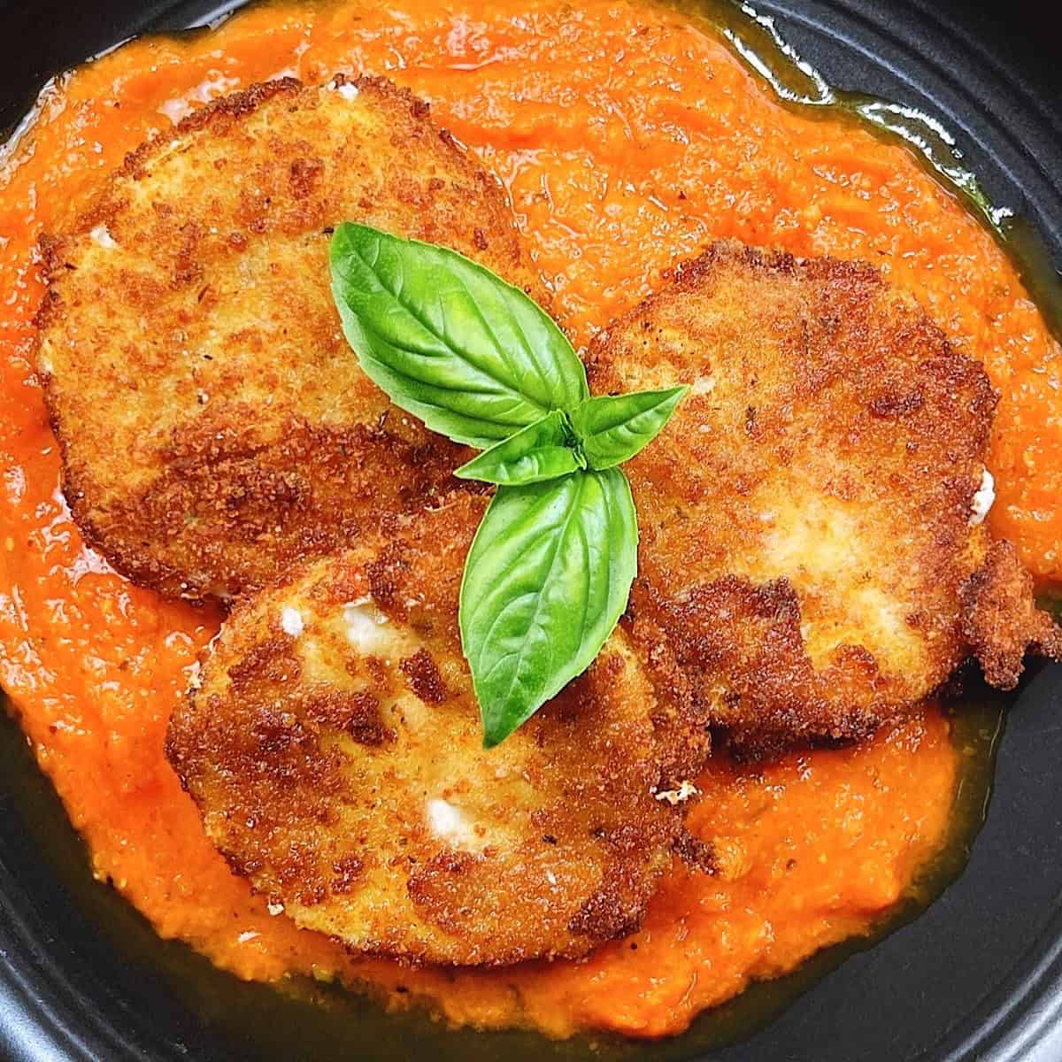 Easy Italian fried cheese recipe with fresh mozzarella and marinara feature image. close up on plate with basil leaves on top