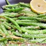 crispy garlic parmesan green beans feature image close up with parmesan and lemon