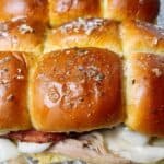 Prepared turkey sliders on a sheet pan with buttery toasted buns.