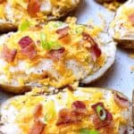 loaded twice baked potatoes with bacon and cheese feature image close up of four potatoes with all the toppings