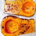 Easy maple roasted butternut squash feature image close up of two halves bruleed