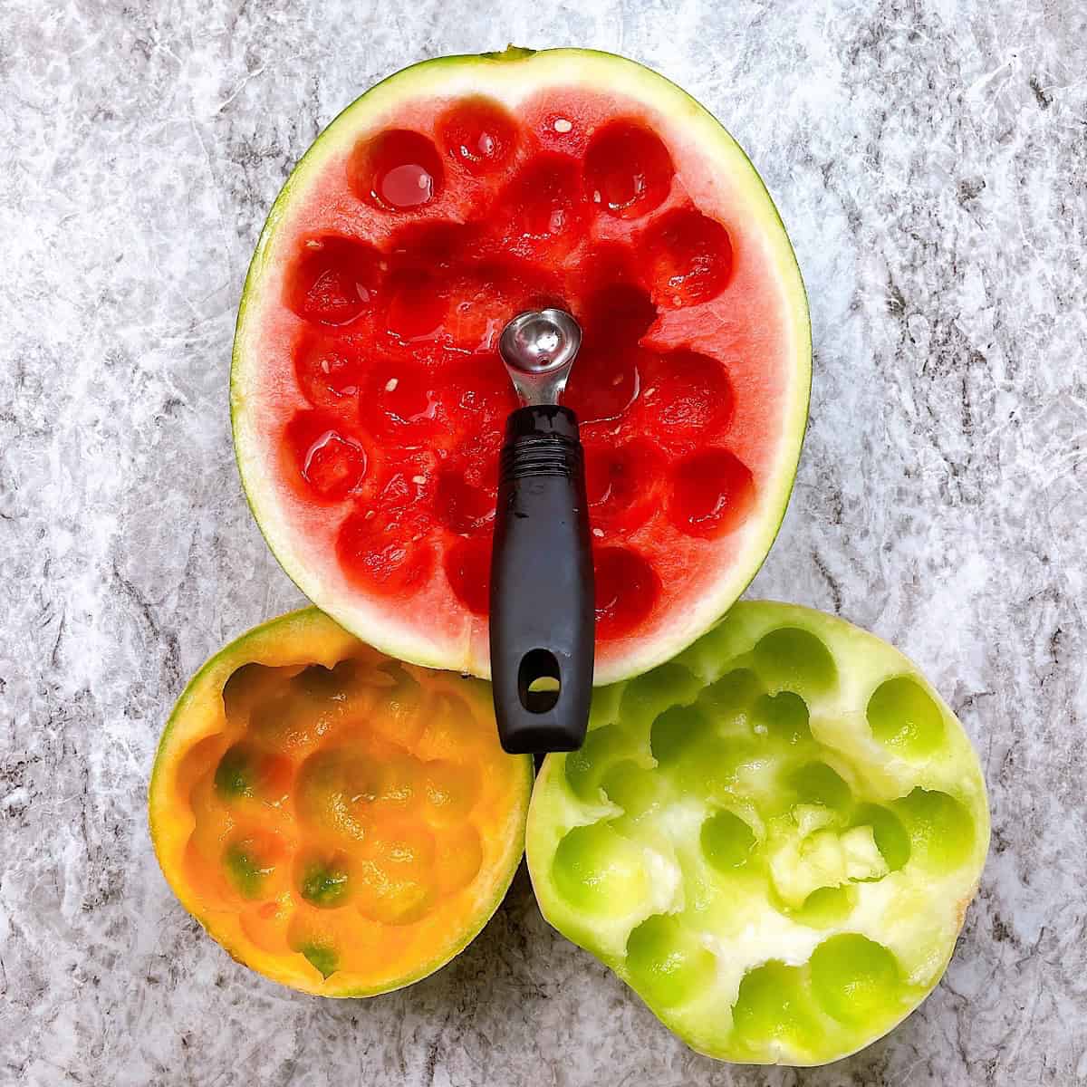 Watermelon, honeydew, and cantaloup with melon balls removed.