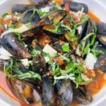 The best mussels marinara with garlic and white wine feature image close up in bowl with all the toppings