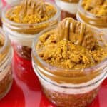 Biscoff cheesecake cups with toppings on a festive plate.
