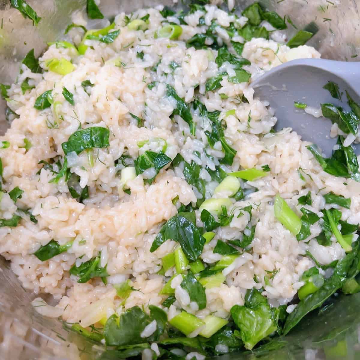 spanakorizo greek spinach rice with lemon and dill process shot 4 adding spinach, green onion, and dill.
