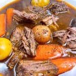 Slow cooker chuck roast with tender vegetables and gravy close up in bowl feature image
