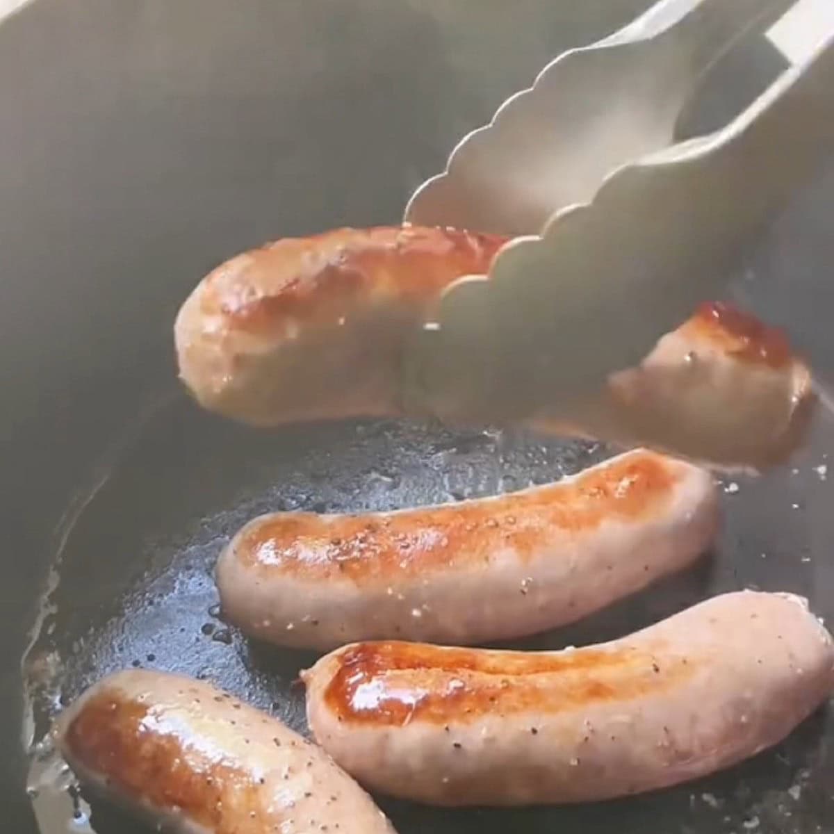 Browned sausages with seasoning in a dutch oven.