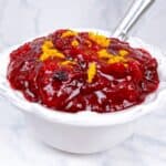 Quick and easy cranberry compote recipe ready in 10 minutes feature image close up in decorative dish with spoon