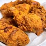 Crispy Cajun Fried Chicken in white bowl on top of paper towel feature image close up.