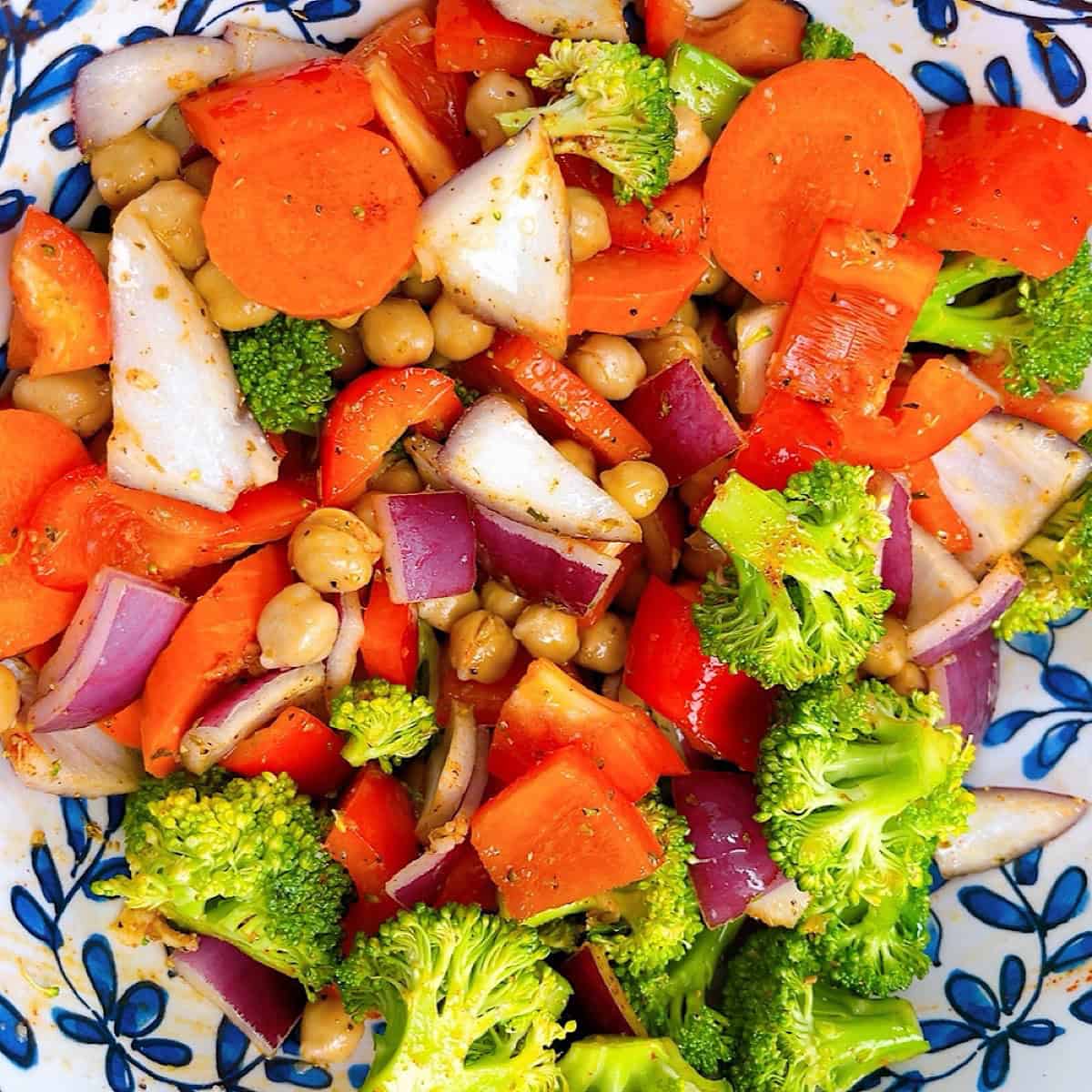 Couscous with roasted veggies, chickpeas, and feta process shot 2 toss vegetables in oil and seasoning.