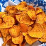Deep fried sweet potato chips feature image close up in bowl on top of a paper towel.