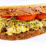 Smashed chickpea and avocado salad sandwich feature image close up with toppings.