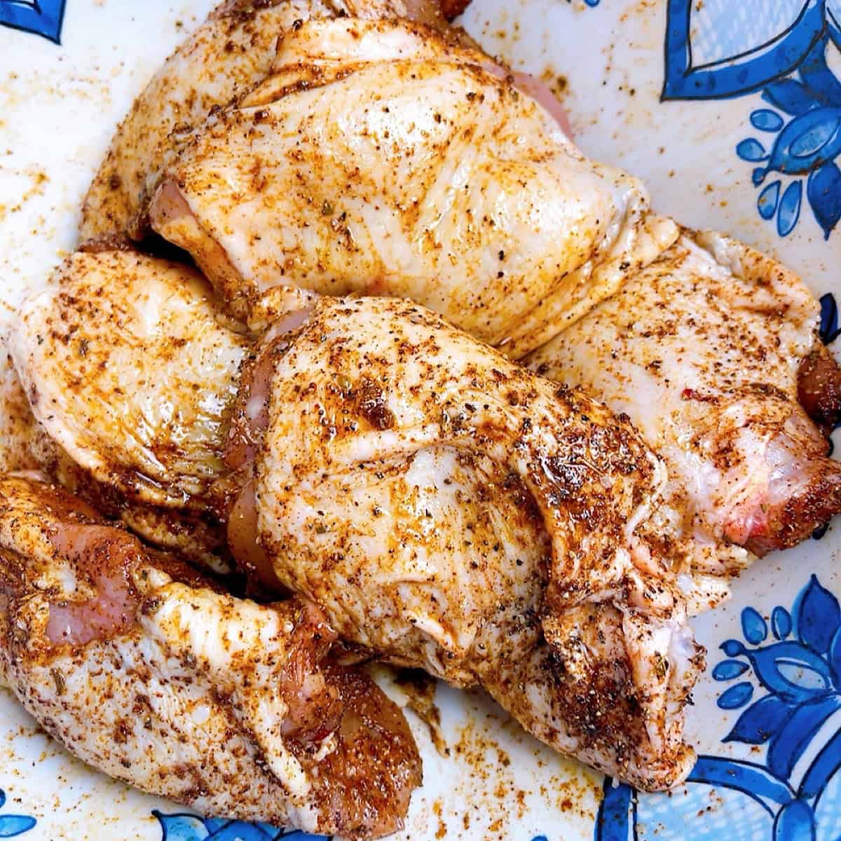Chicken thighs in seasoning.