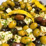 Quick and easy marinated olives with feta cheese feature image close up in white bowl with rind.