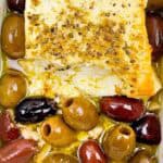 Baked feta appetizer surrounded by olives.