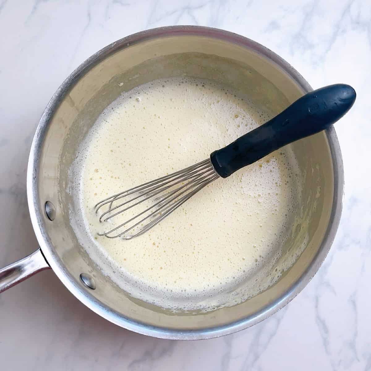Lemon sauce in stainless steel pan.