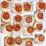 Triscuit pizza on parchment baked with seasonings.