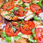 Caprese chicken with melted cheese, balsamic drizzle, and basil chiffonade.