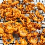 Onion straws on a wire rack.
