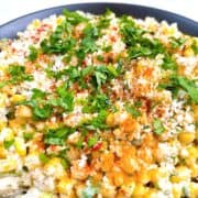 Elote corn dip in black bowl with garnish.