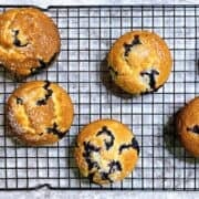Baked buttermilk blueberry muffins on a wire rack.