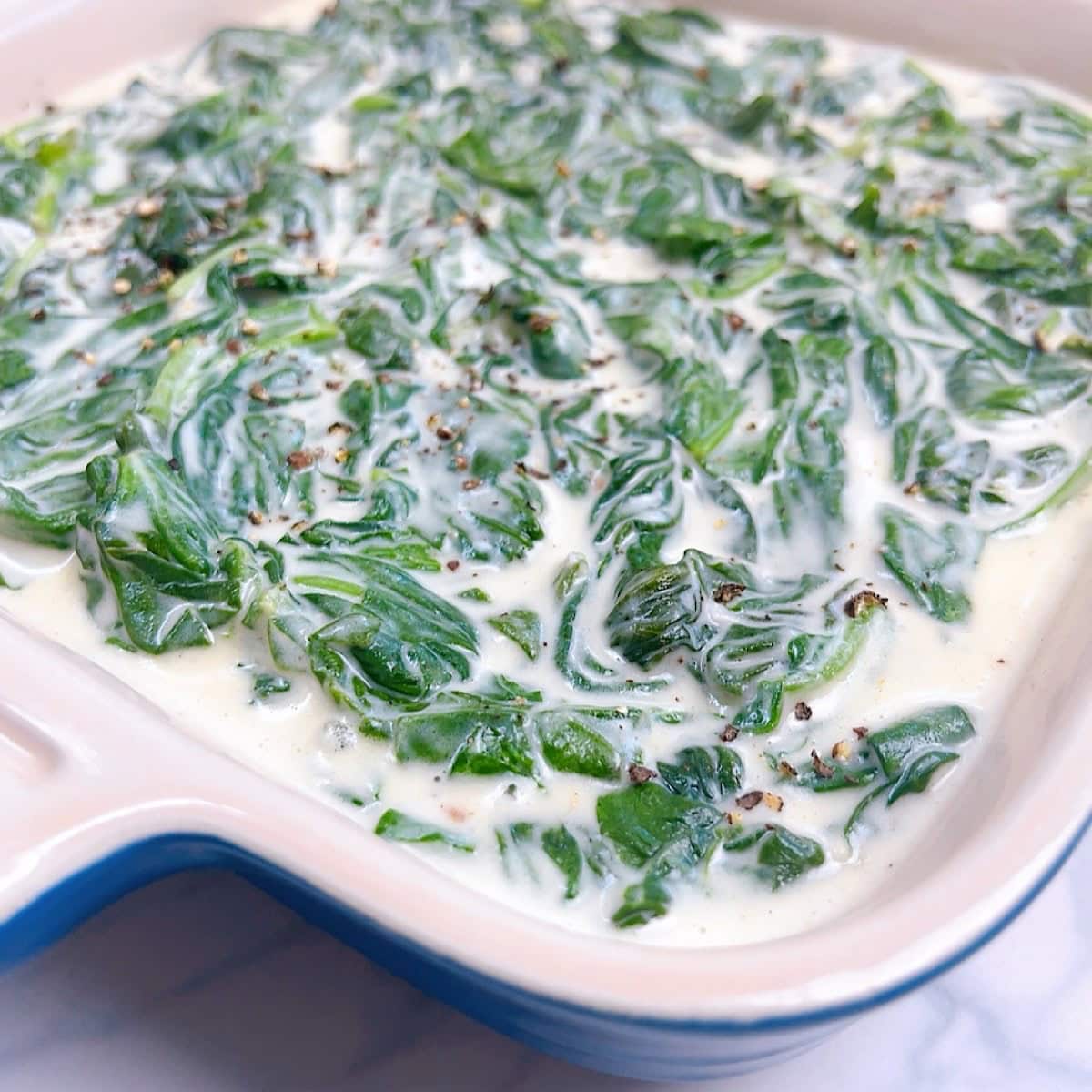 An image of steakhouse spinach in a small blue casserole dish.