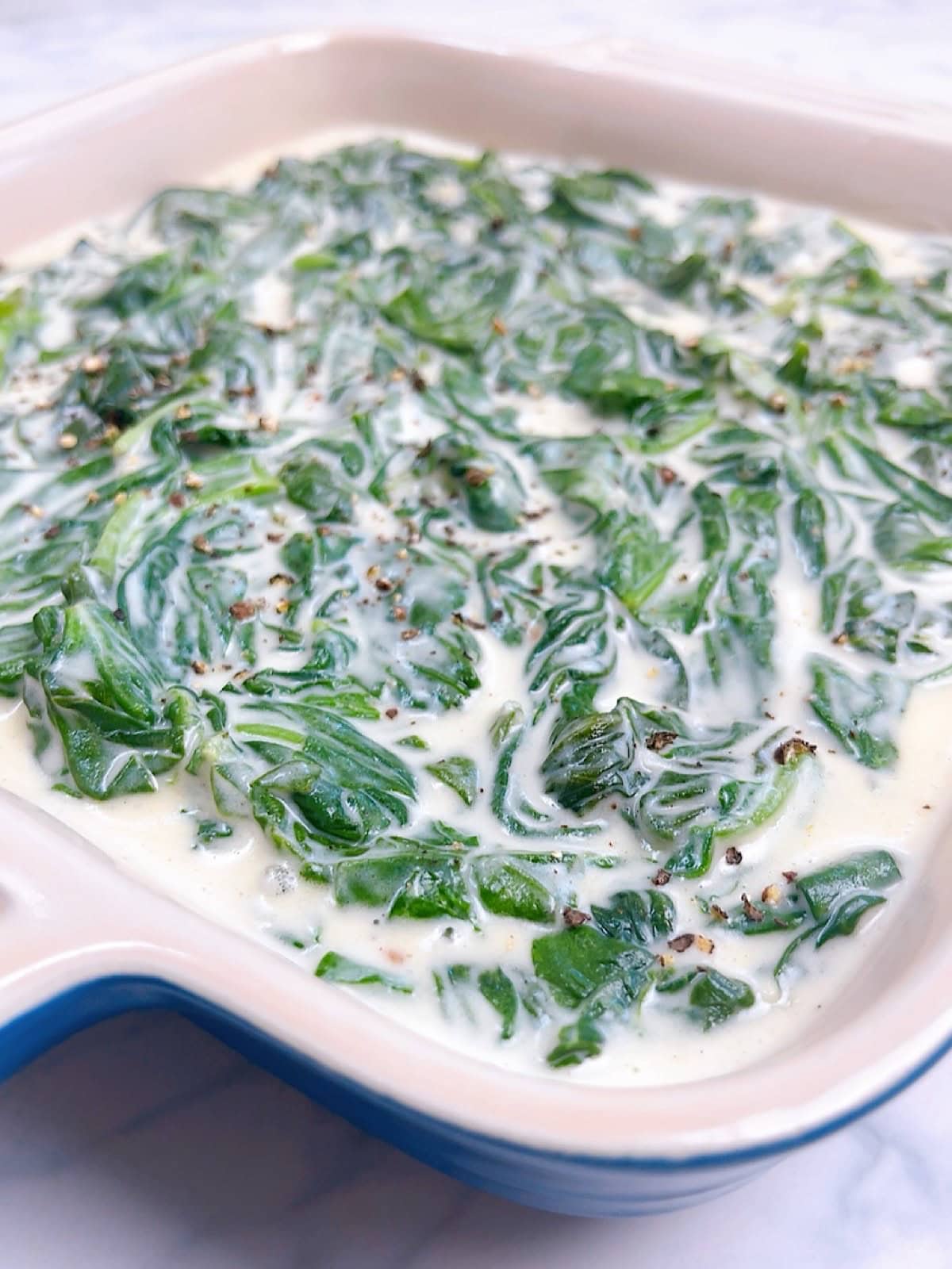 An image of steakhouse spinach in a small blue casserole dish.