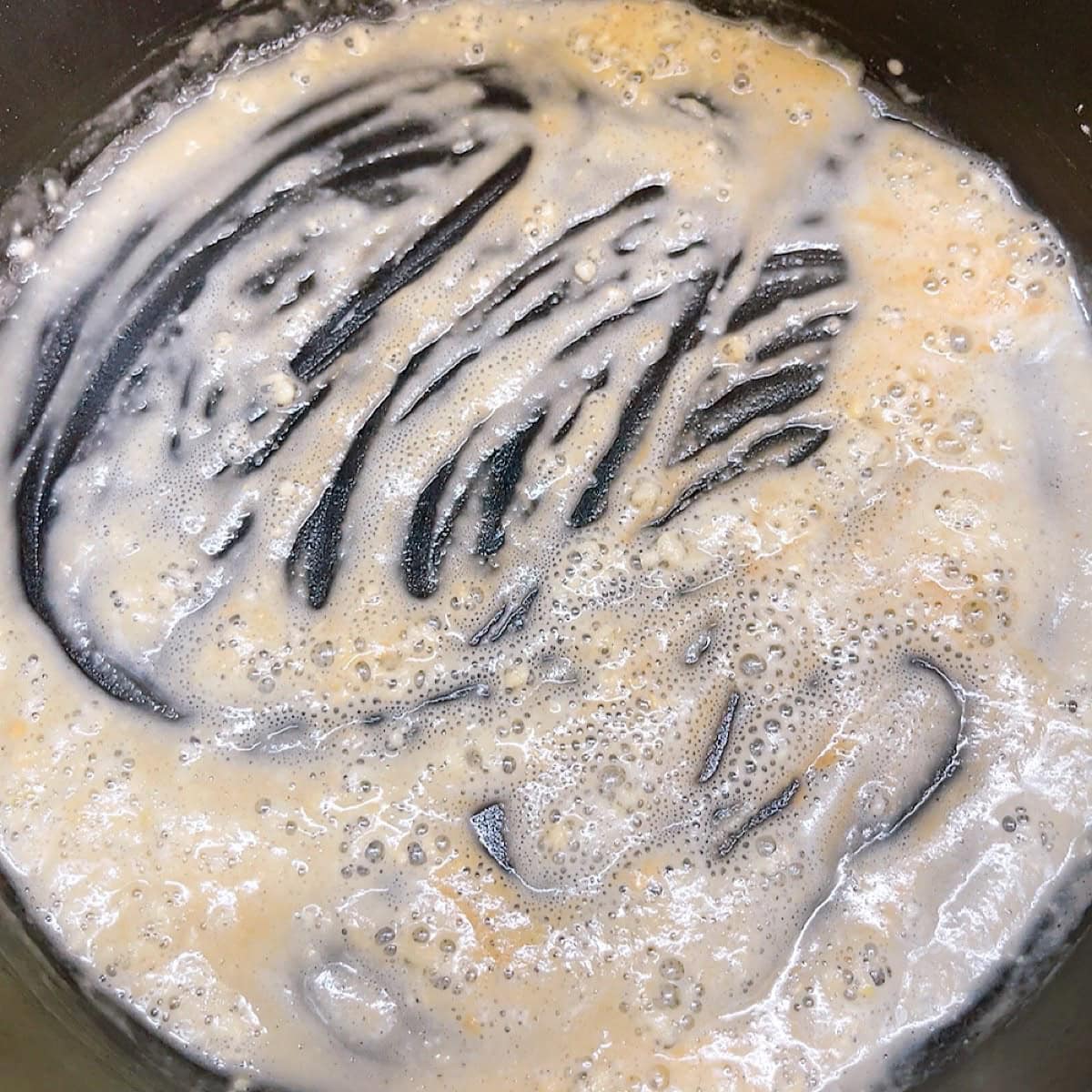 Whisking butter with flour to make the roux.