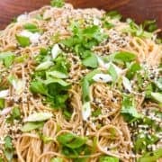 Soba noodle salad with garnish in wooden salad bowl.