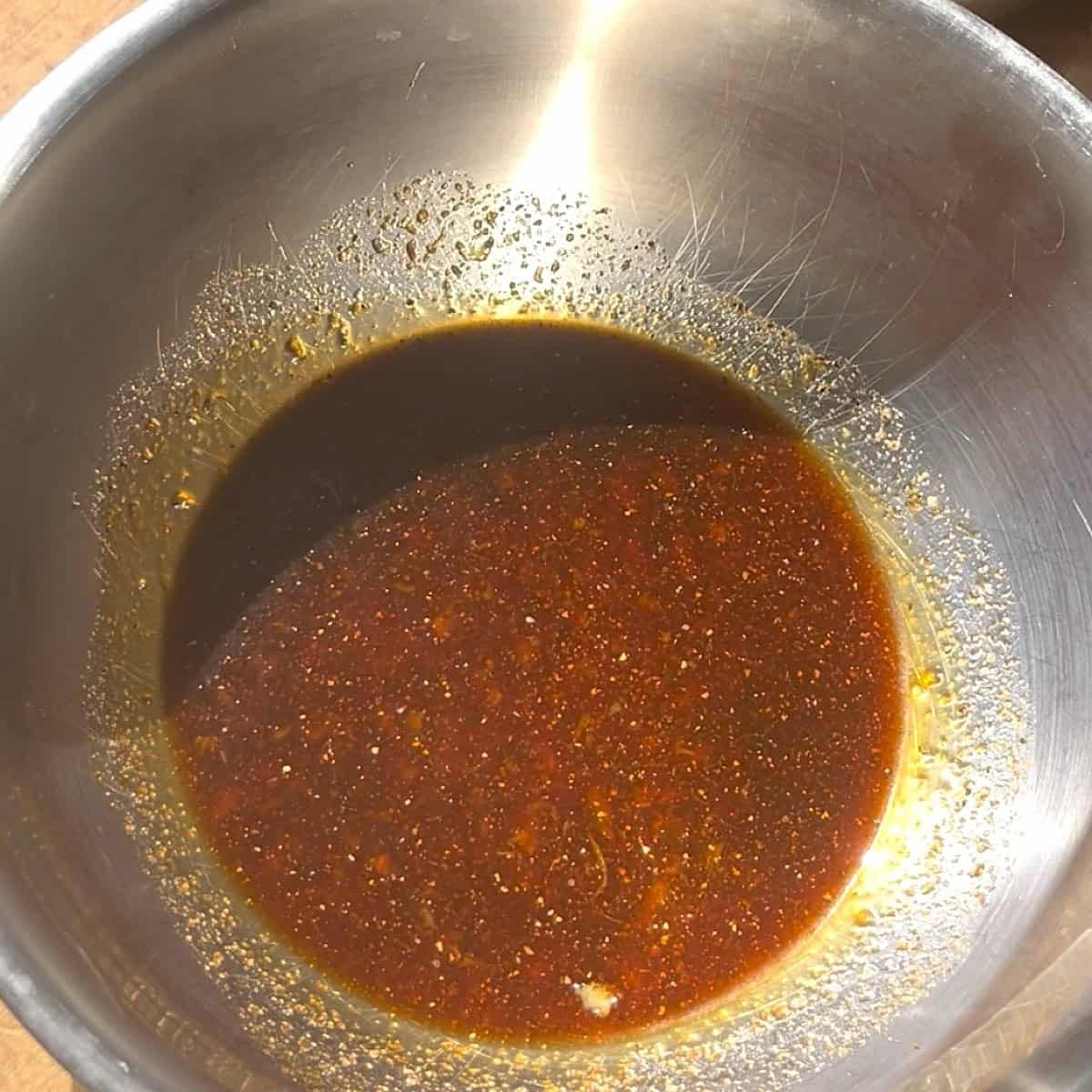 Sauced whisked together  in a stainless steel bowl.