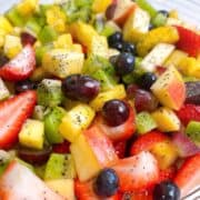 Fresh fruit salad tossed in a glass bowl and ready to serve.