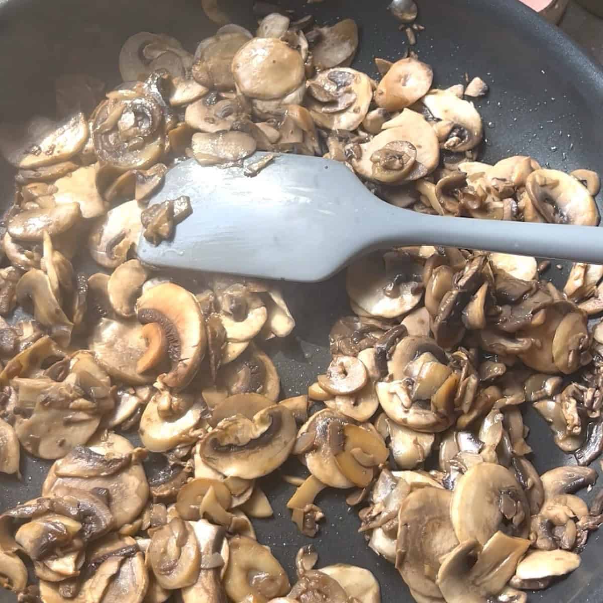 Sauteeing mushrooms in a skillet.