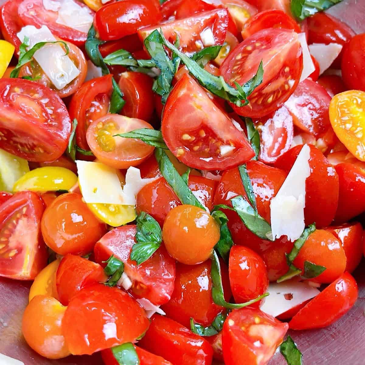 Tomato wedges marinating with basil, garlic, and dressing.
