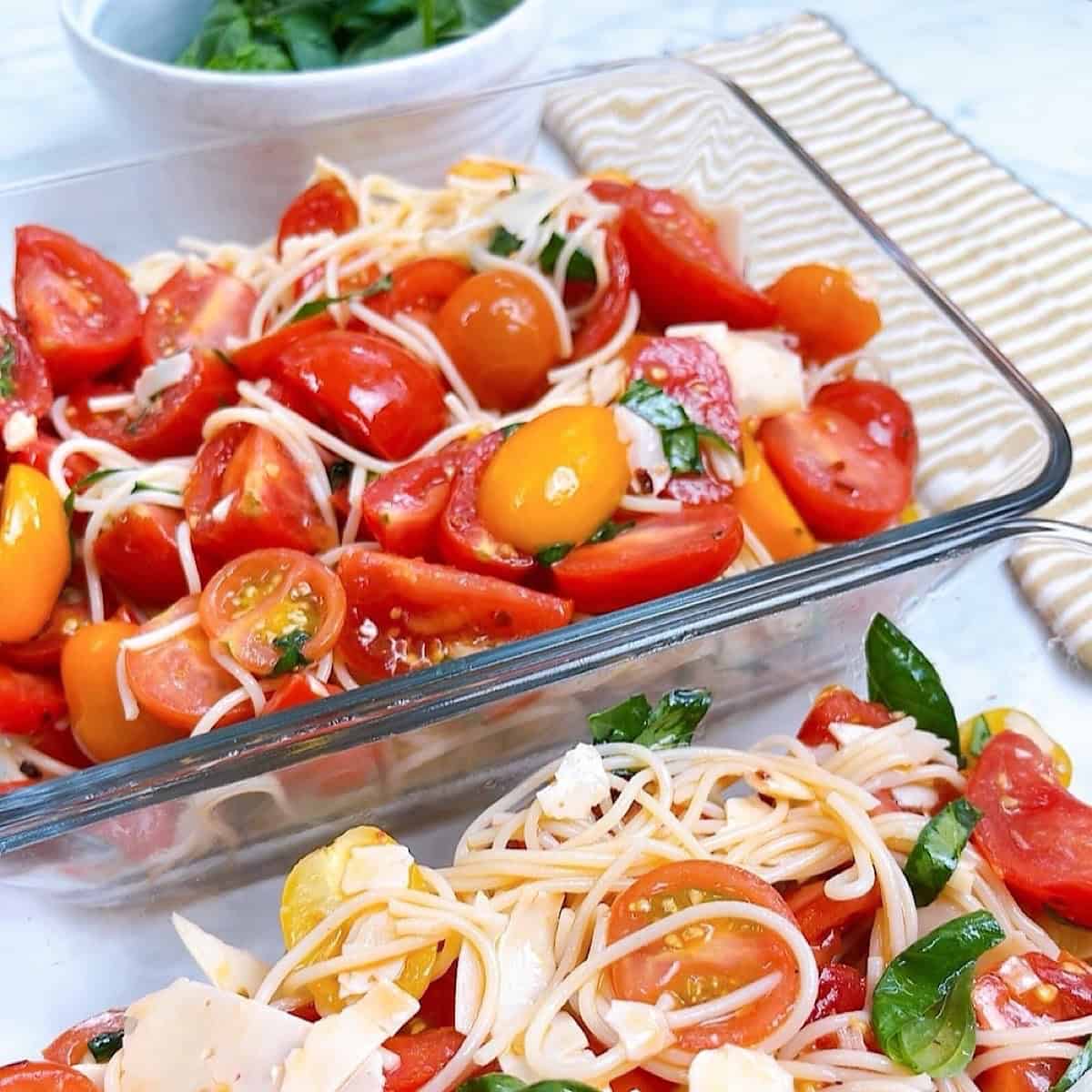 Pasta combined with tomatoes in two meal prep glass containers.