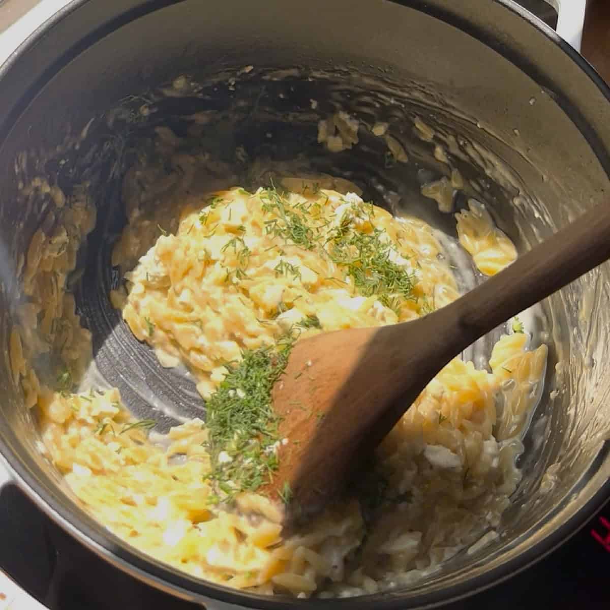 Folding in the feta and dill off the heat.