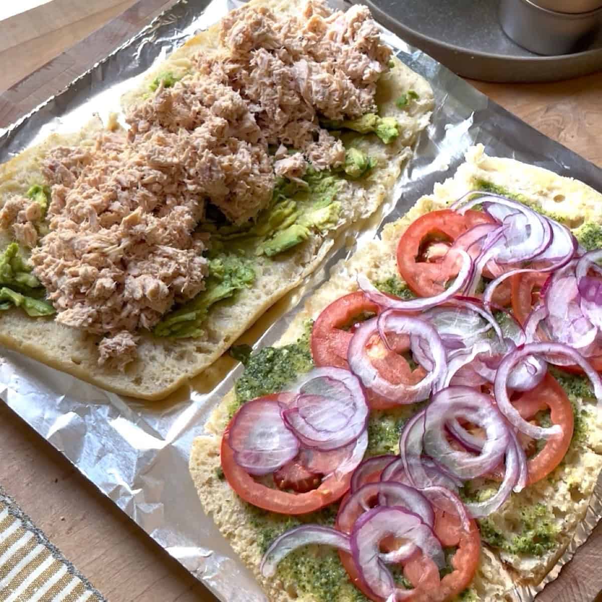 Each toasted ciabatta slice open face with ingredients on top.