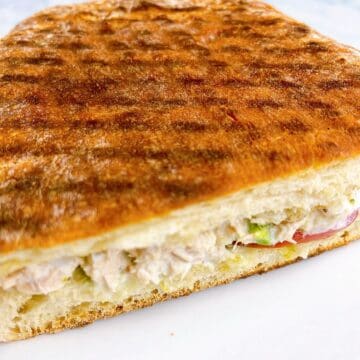 Toasted and halved tunacado sandwich with inside showing