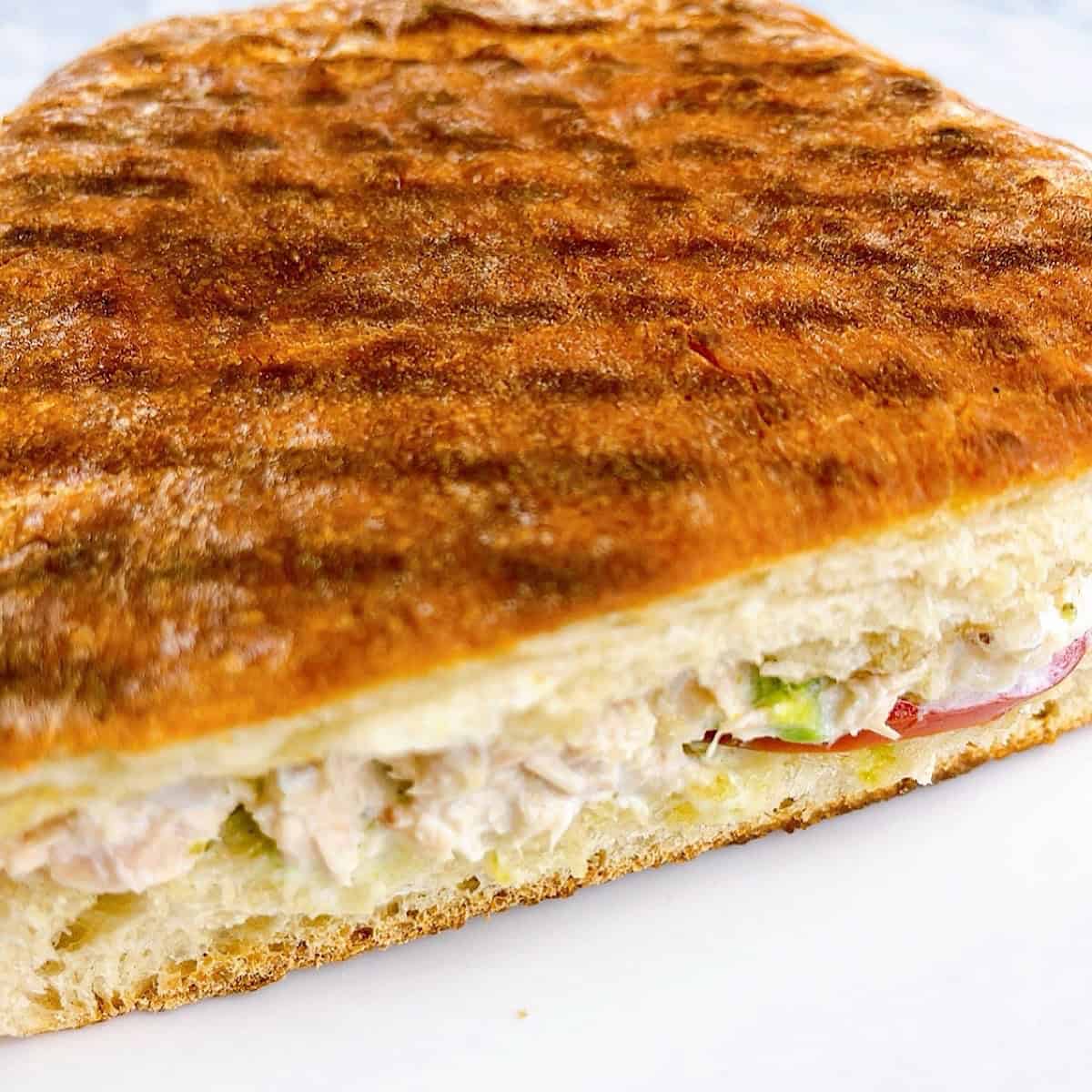 Toasted and halved tunacado sandwich with inside showing