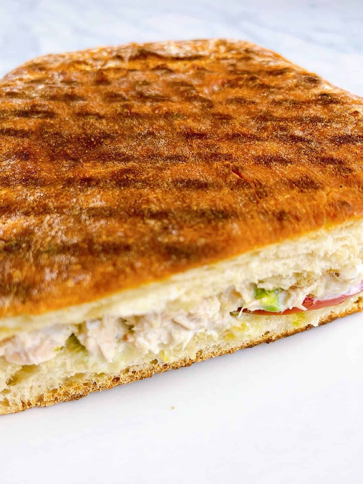 Toasted and halved tunacado sandwich with inside showing