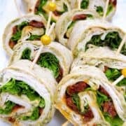 Turkey pinwheels arranged on platter with skewers.