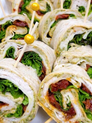 Turkey pinwheels arranged on platter with skewers.