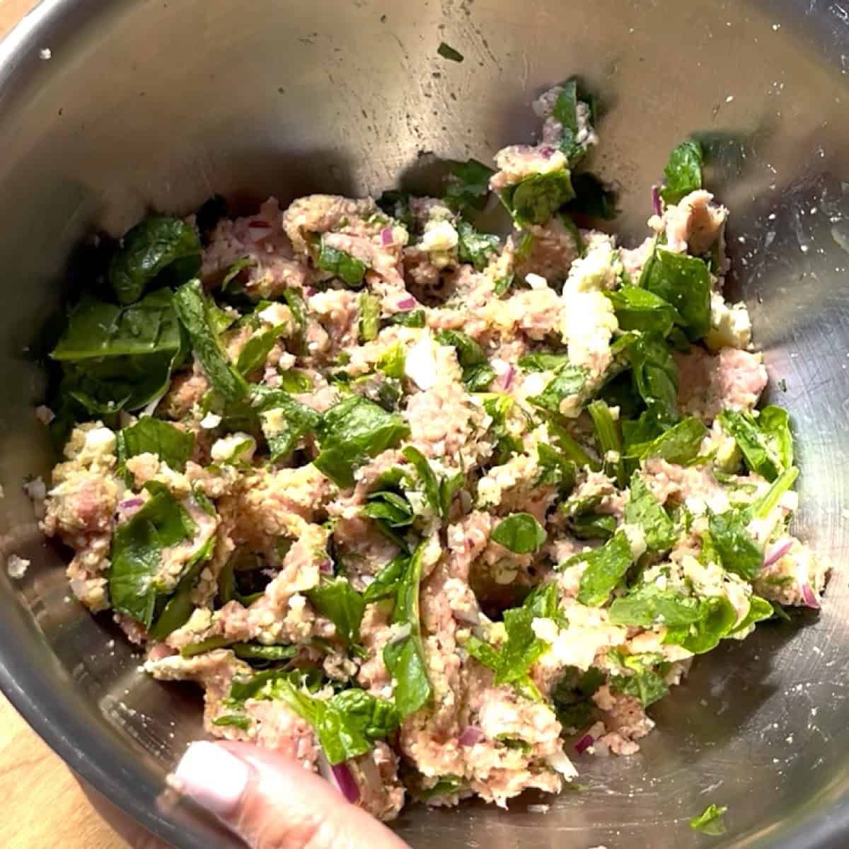 Spinach and feta turkey burger ingredients mixed in a bowl.