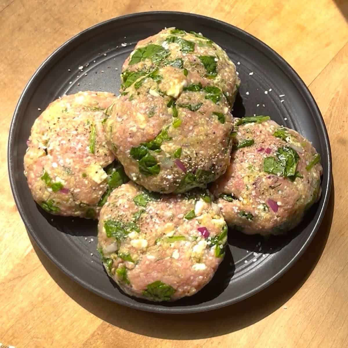 Turkey burger patties shaped on a plate.