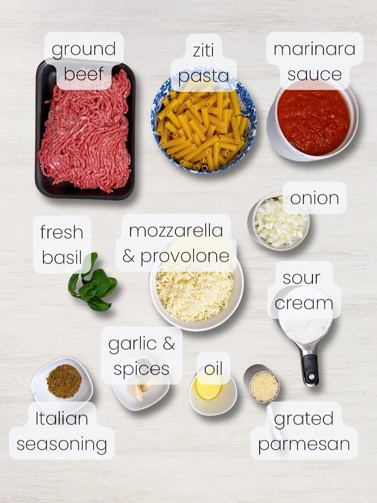 A labeled image of everything needed to make baked ziti with ground beef.